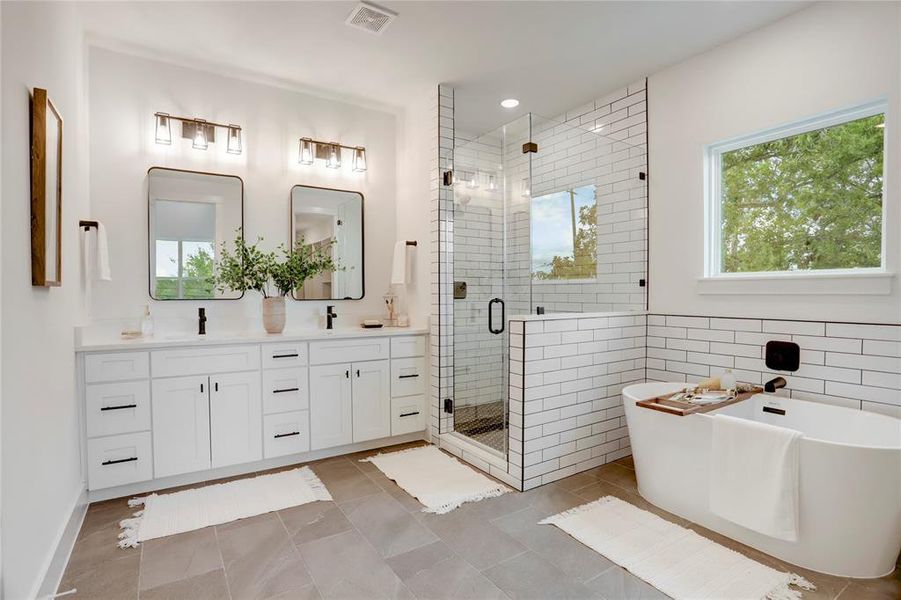 The primary bath has solid wood cabinets, custom lighting, 3cm quartz counters, and Moen fixtures.