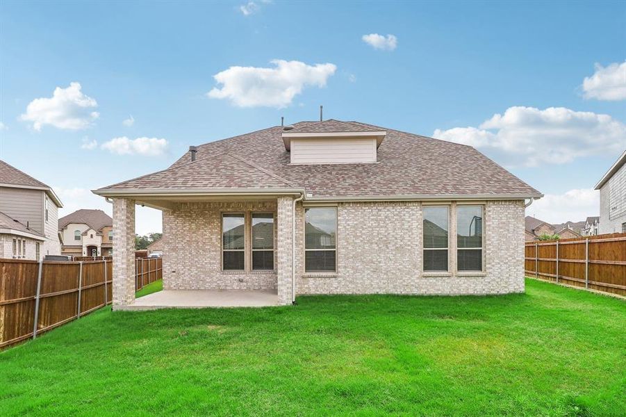 Rear view of property with a lawn and a patio area