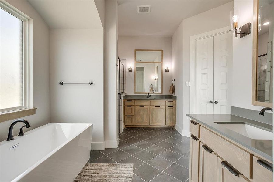 Bathroom with vanity, a tub to relax in, and tile patterned floors