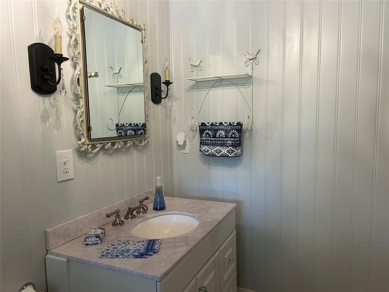 Bathroom with vanity and wooden walls