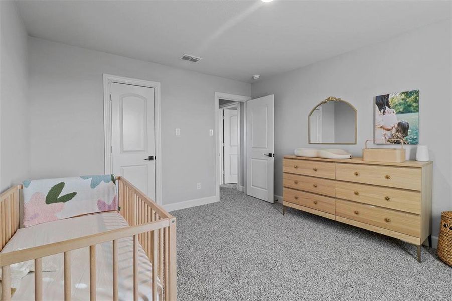 Bedroom featuring carpet floors and a crib