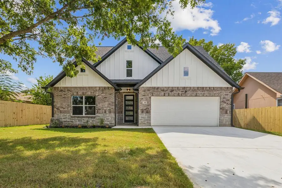 View of front of home featuring a garage and a front yard