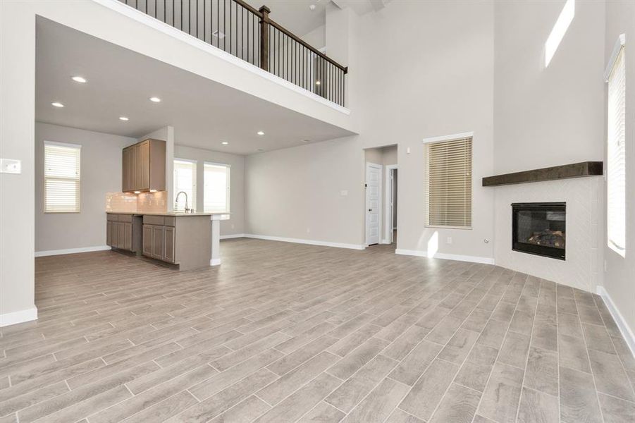 Bring the family and guests together in the welcoming family room! Enjoy the expansive space adorned with high ceilings, recessed lighting, a stylish ceiling fan, custom paint, exquisite flooring, and generously sized windows that fill the room with an abundance of natural light, creating a warm and inviting atmosphere for everyone to enjoy. Sample photo of completed home with similar floor plan. As-built interior colors and selections may vary.