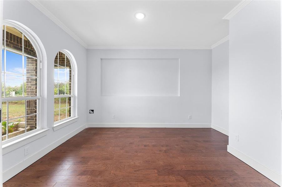 Spare room with dark hardwood / wood-style flooring and ornamental molding