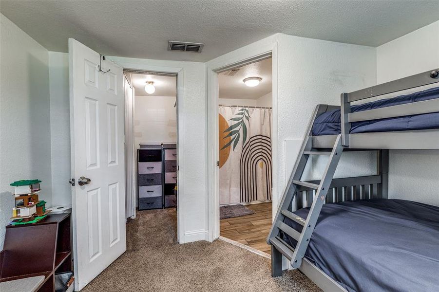Secondary bedroom with walk-in closet and full bathroom with tub