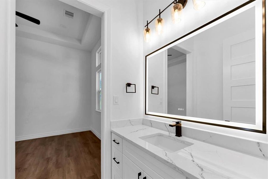 The third bedroom's private vanity with sink, anti-fog LED mirror, quartz countertop and undercabinet storage.