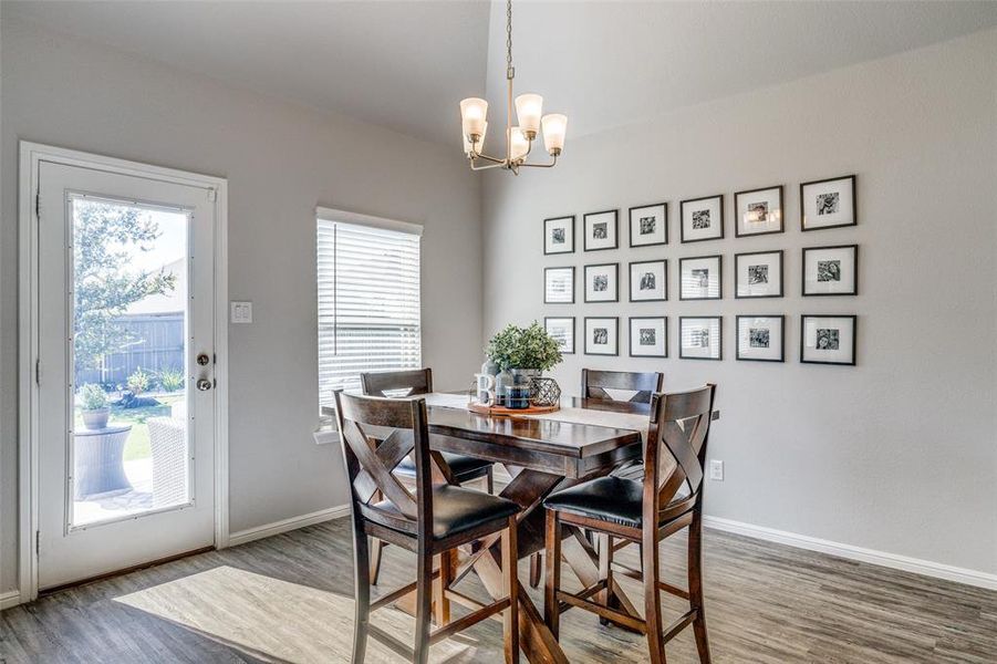 Dining room featuring wood-style flooring and a notable chandelier