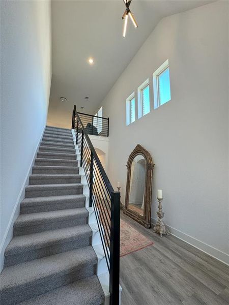 Stairway featuring lofted ceiling and hardwood / wood-style flooring