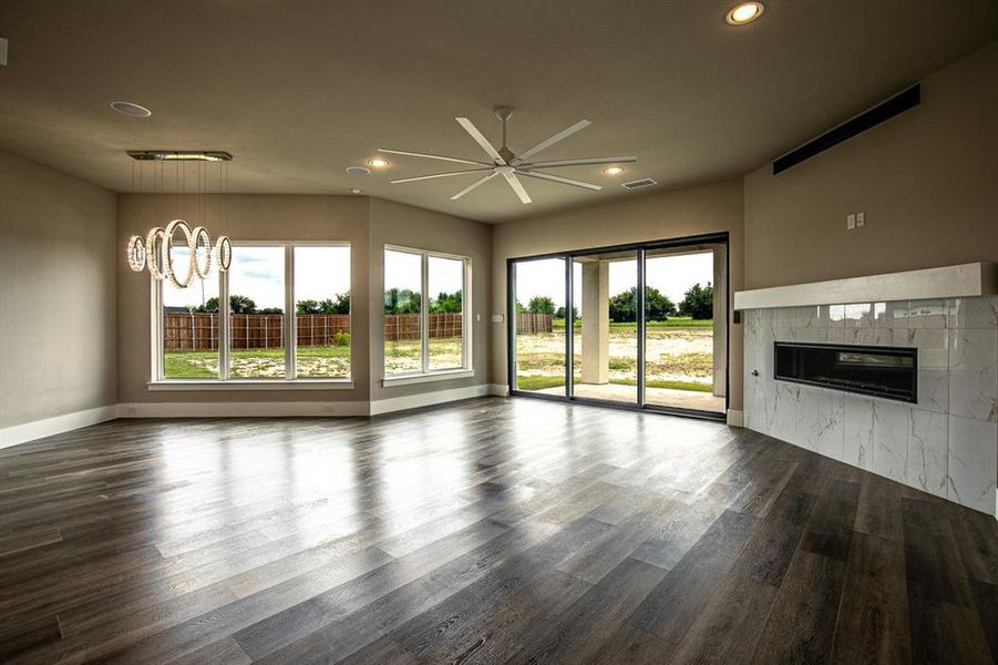 Living room featuring a tiled fireplace, ceiling fan