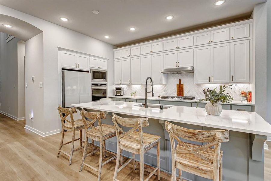 The kitchen is the heart of the home with a huge center island with bathed in quartz and ready to seat a crowd for your next gathering.