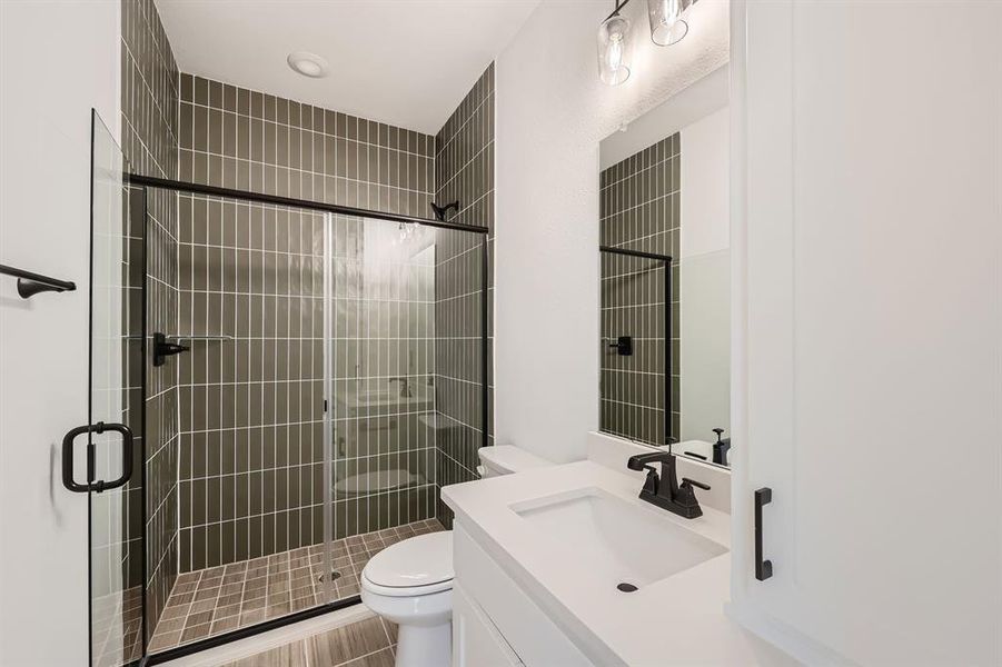 Bathroom with walk in shower, vanity, and toilet