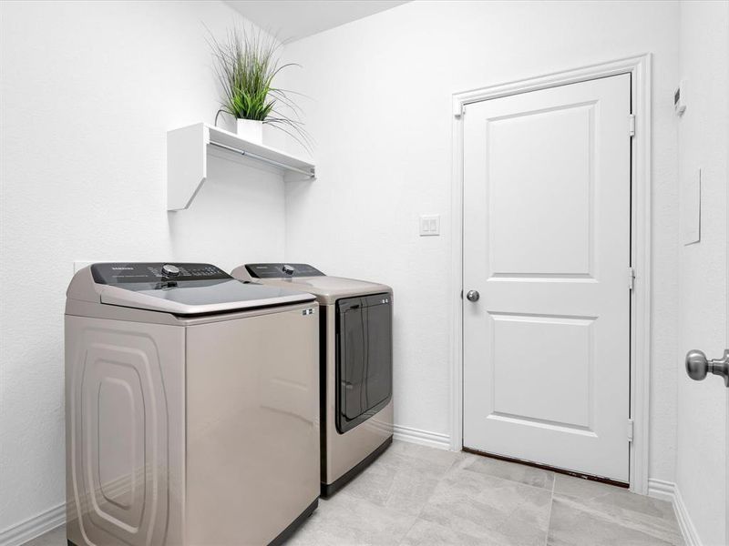 Laundry area featuring light tile patterned flooring and washing machine and dryer
