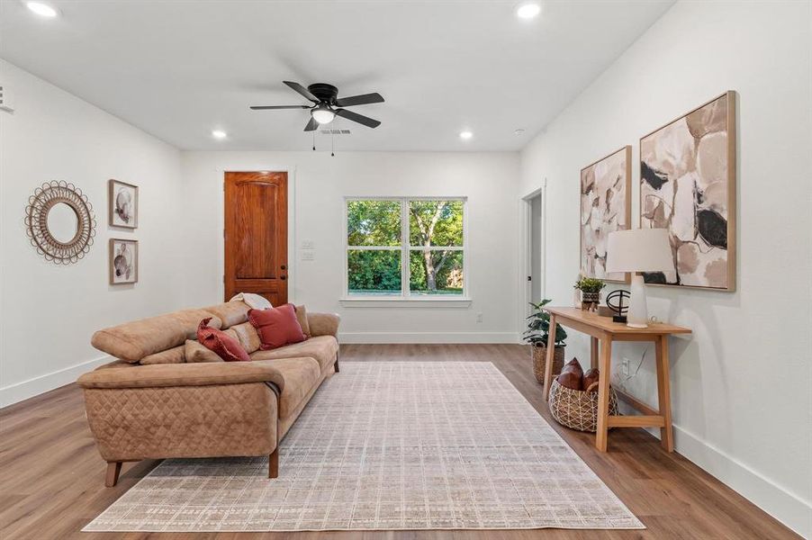 Living room with ceiling fan and light wood-type flooring