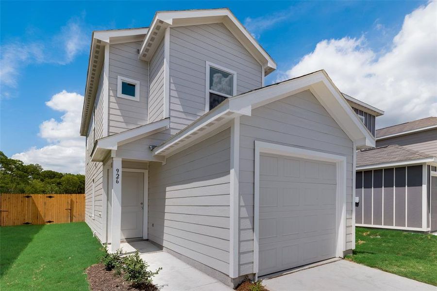 View of front of house with a garage and a front lawn