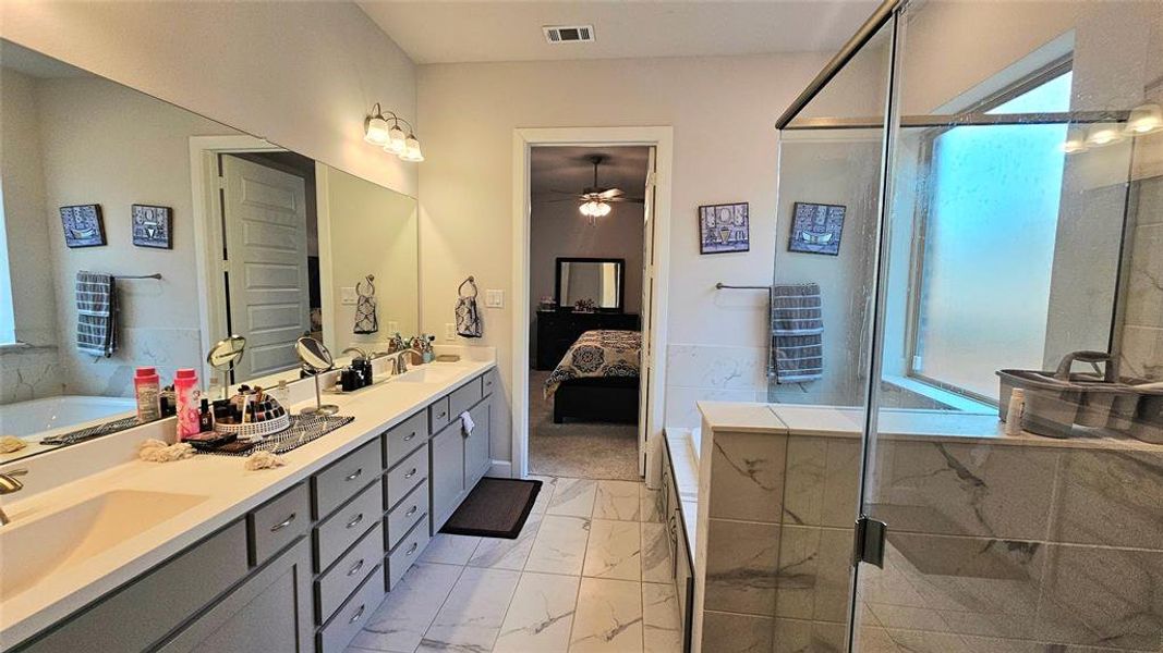 Bathroom featuring shower with separate bathtub, dual vanity, tile patterned floors