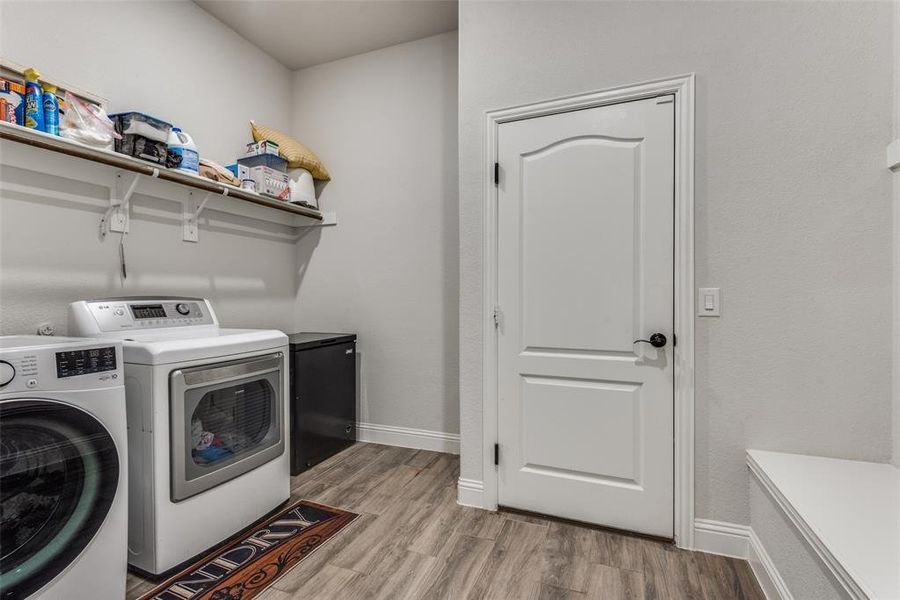 Washroom featuring wood-type flooring and washer and dryer