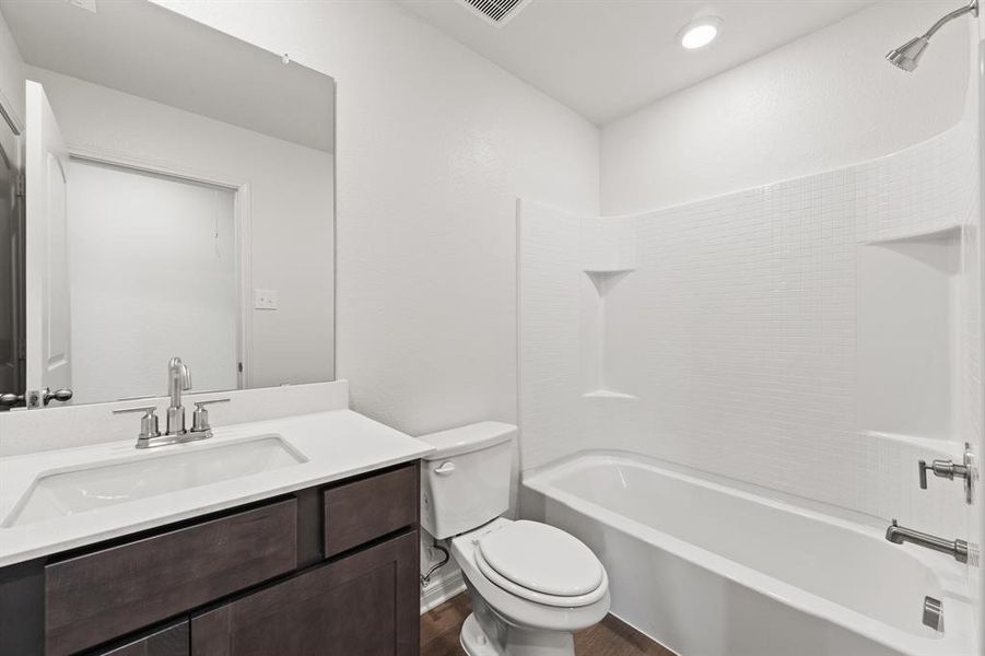 Full bathroom with shower / bathing tub combination, vanity, toilet, and wood-style flooring