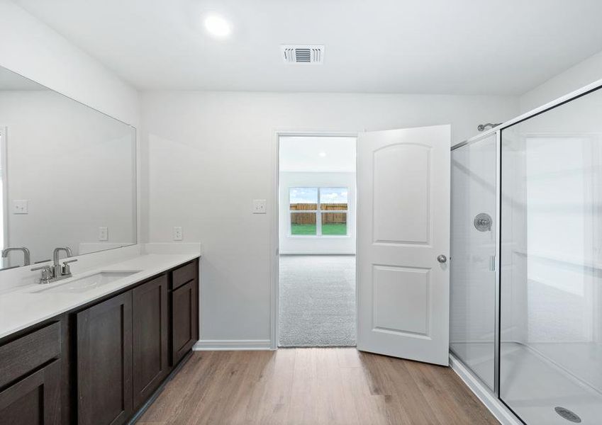 The master bathroom has a large glass, walk-in shower.