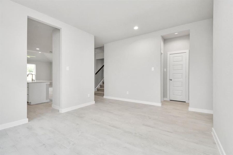 Create lasting memories with your family and friends at the dining table! This expansive dining room showcases sophisticated flooring, custom paint, and seamlessly connects to the family room and kitchen, providing an open and inviting atmosphere.