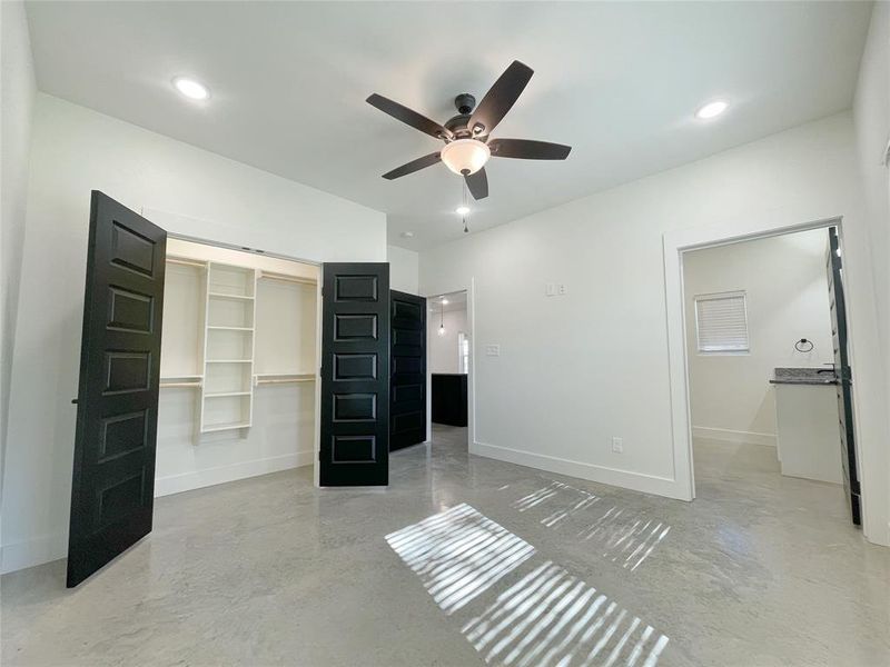 Unfurnished bedroom with ceiling fan, a closet, and a walk in closet