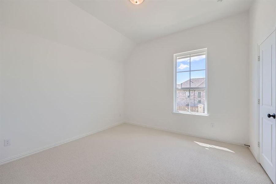 Bonus room featuring vaulted ceiling and light colored carpet