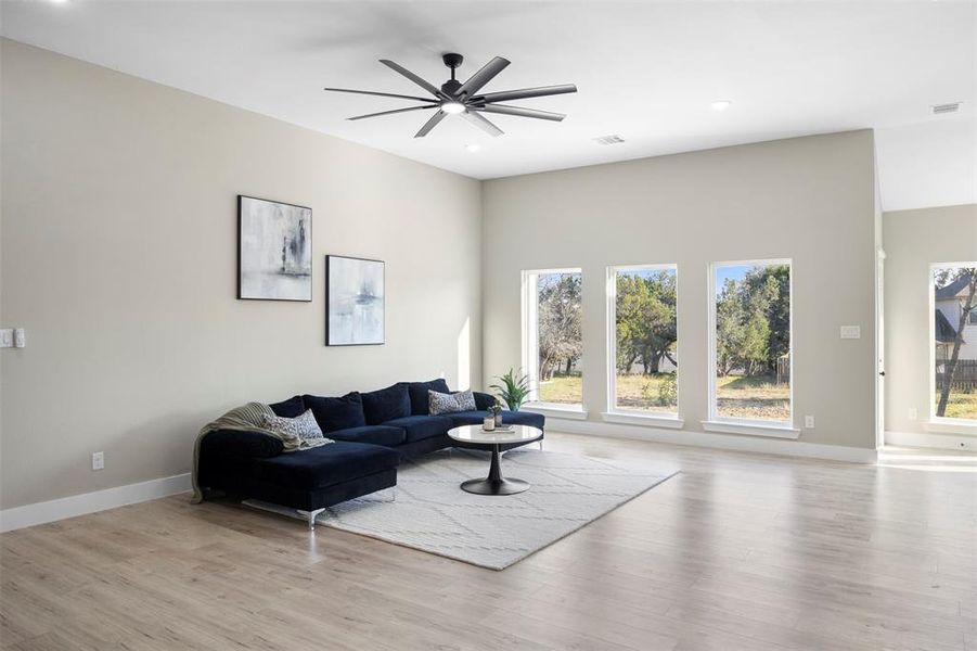 Living room with ceiling fan and light wood-type flooring