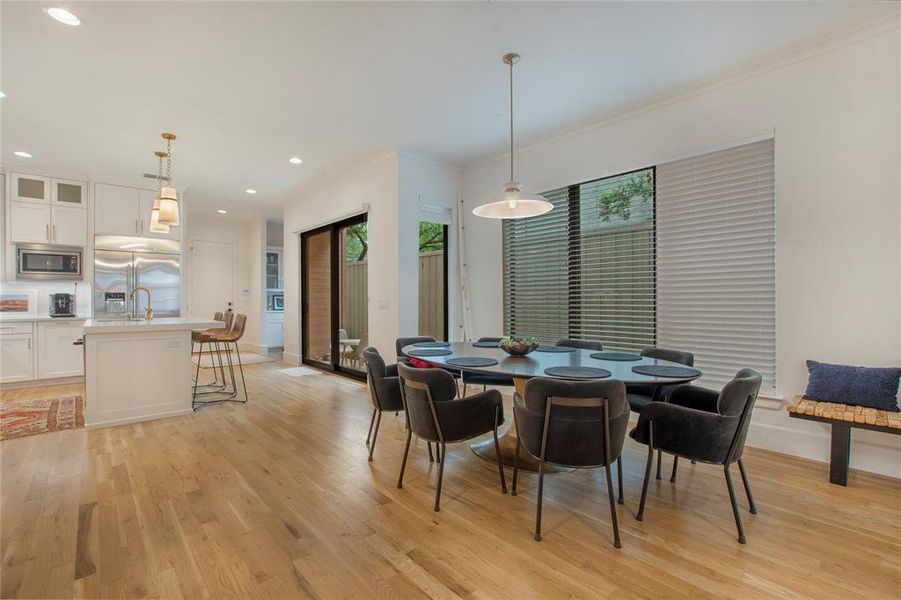 Dining area featuring sink, light hardwood / wood-style flooring, and crown molding