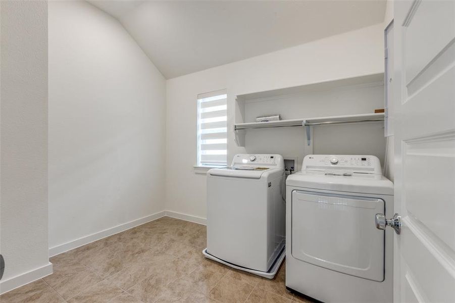 Washroom featuring separate washer and dryer and light tile patterned floors