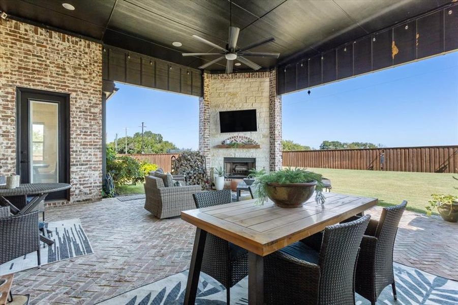 View of patio featuring ceiling fan and an outdoor stone fireplace