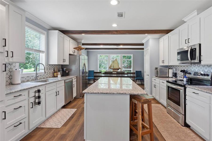 Wow! This kitchen has everything you need for intimate dining, entertaining, or daily life! It has granite countertops, an incredible backsplash, and storage, and the vinyl floors offer easy cleanup.