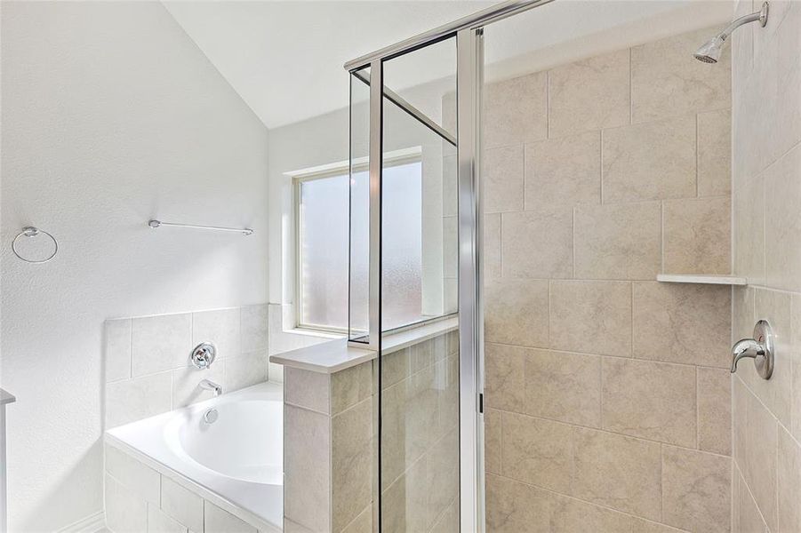 Bathroom with lofted ceiling and plus walk in shower