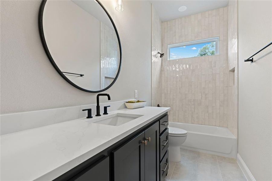 Full bathroom with toilet, tiled shower / bath, vanity, and tile patterned floors