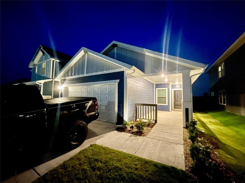 Property exterior at twilight with a yard and a garage