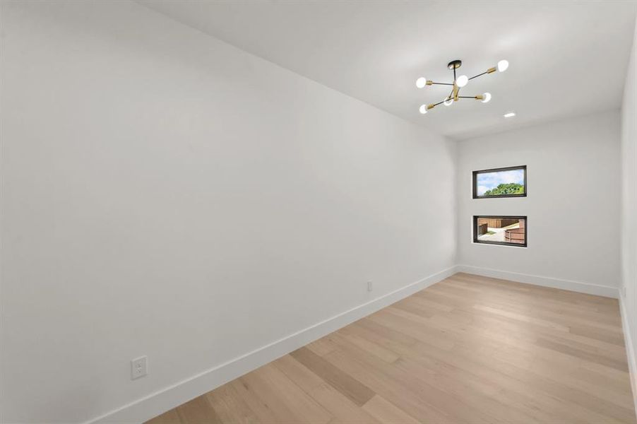 Flex/Yoga room with a chandelier and light hardwood / wood-style floors