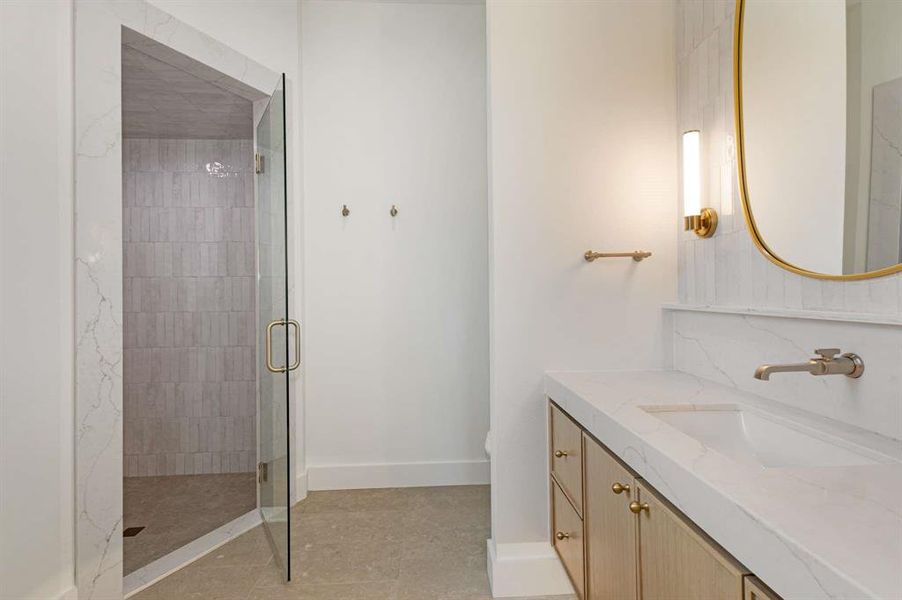 Bathroom featuring vanity, tile patterned flooring, and a shower with door