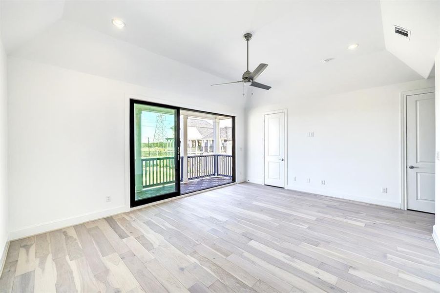 Primary suite with vaulted ceilings and a balcony