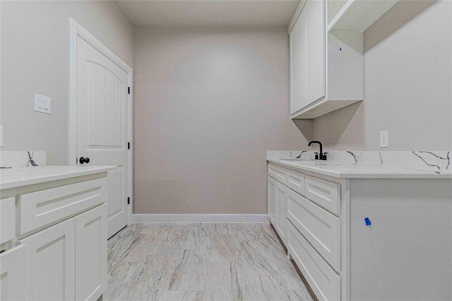 Washroom with sink and light tile patterned floors