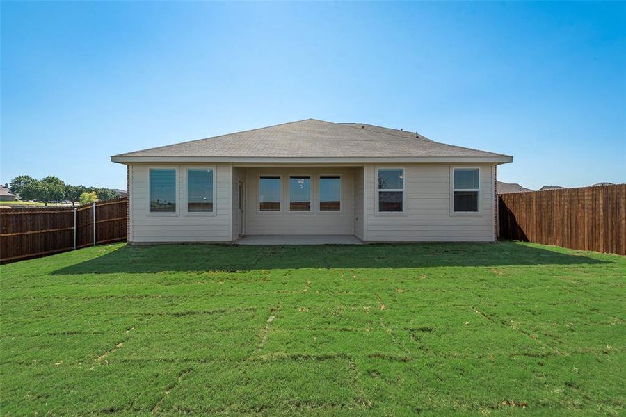 Rear view of house with a patio area and a lawn