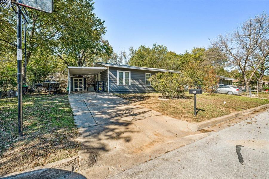 Ranch-style home with a carport and a front lawn