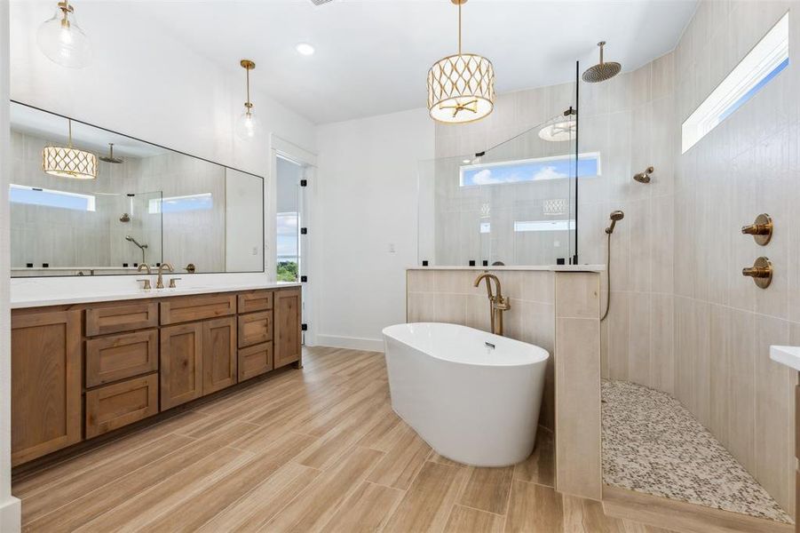 Bathroom featuring tile walls, independent shower and bath, and vanity