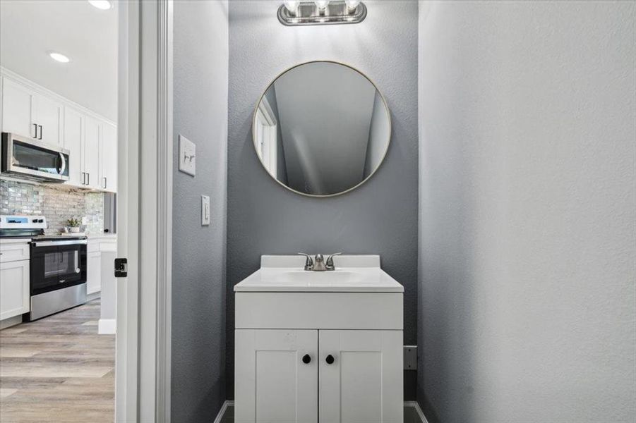 Bathroom with wood-type flooring, tasteful backsplash, and vanity