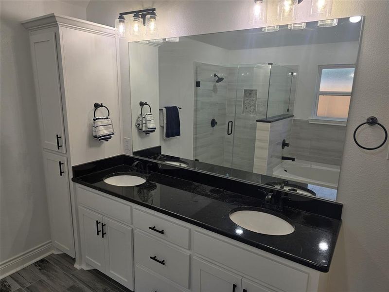 Bathroom featuring shower with separate bathtub, vanity, and hardwood / wood-style flooring