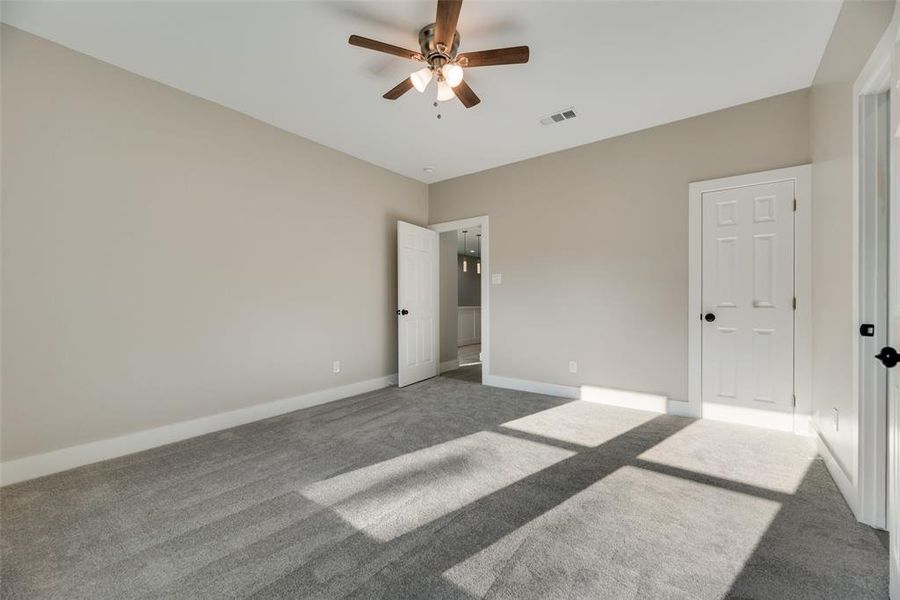 Unfurnished bedroom featuring carpet flooring and ceiling fan