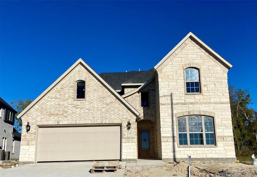 Gorgeous stone & brick elevation with large tree line behind. Estimated completion in January. Interior photos are different completed homes with same colors.