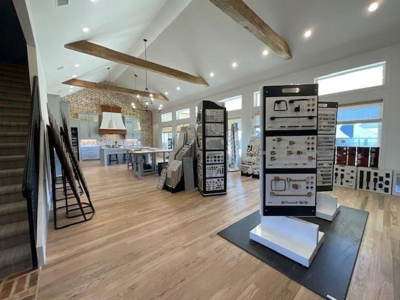 Workout room featuring an inviting chandelier, high vaulted ceiling, and light wood-type flooring