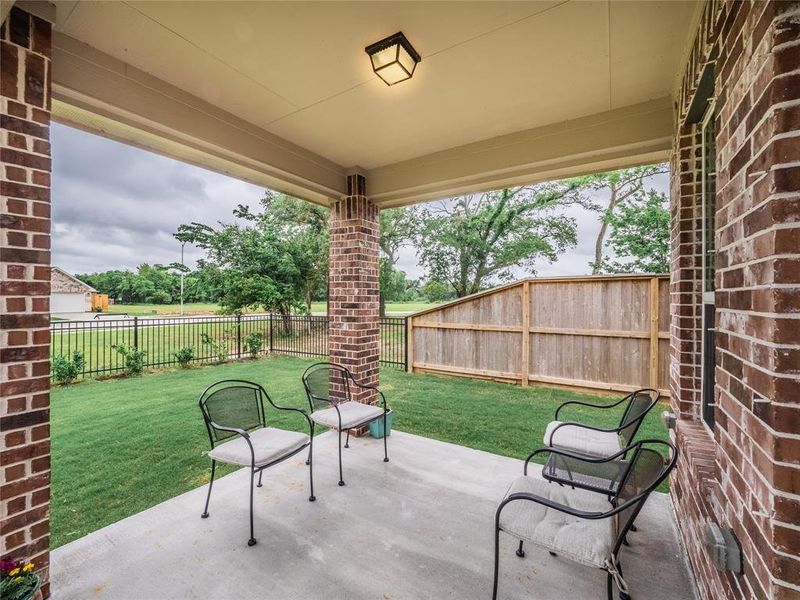 the covered patio is spacious, and you have your privacy fence on both side and the iron fence in the back