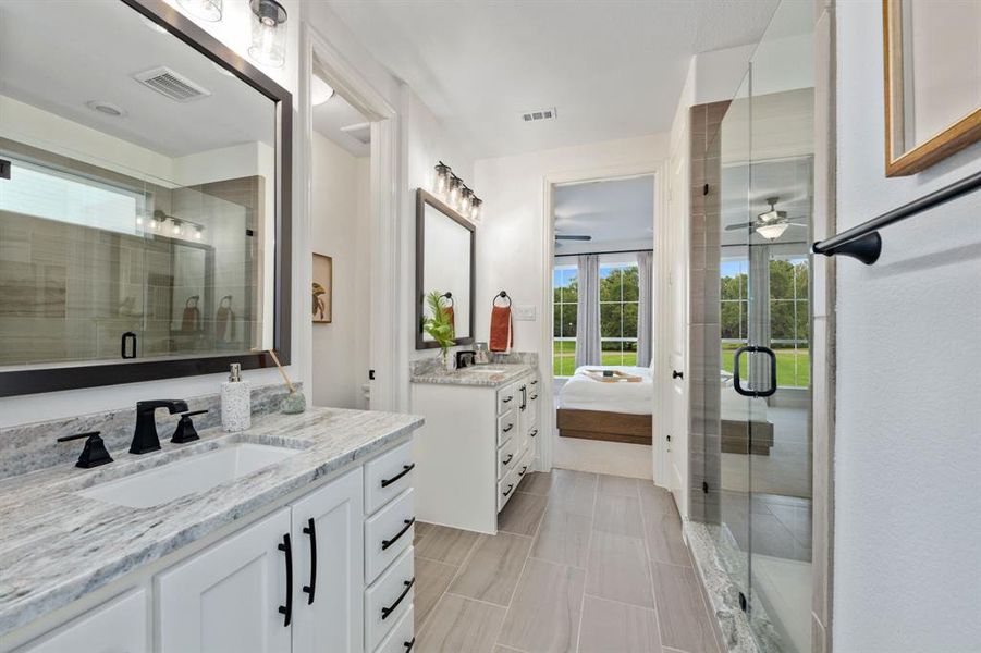 Main bathroom featuring vanity, a shower with shower door, and ceiling fan