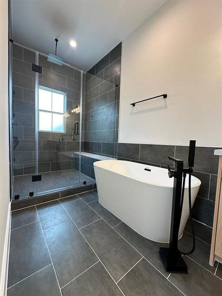 Primary Bathroom. Features soaker tub and custom tiled oversized shower with rainfall shower head.