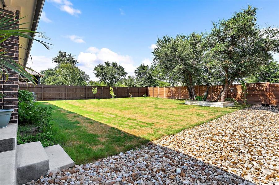 Look a this amazing yard!  featuring no neighbors directly behind for ultimate privacy.  It comes with full sod and sprinkler system, stone lined flower beds and low maintenance stone side yard plus added fruit trees