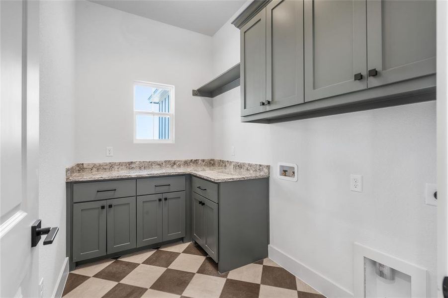 Laundry room offers space for folding, storage with entry from the garage.